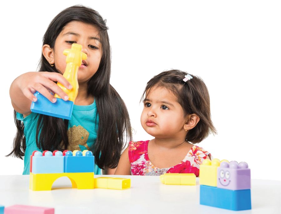 Two young girls playing with building blocks at preschool